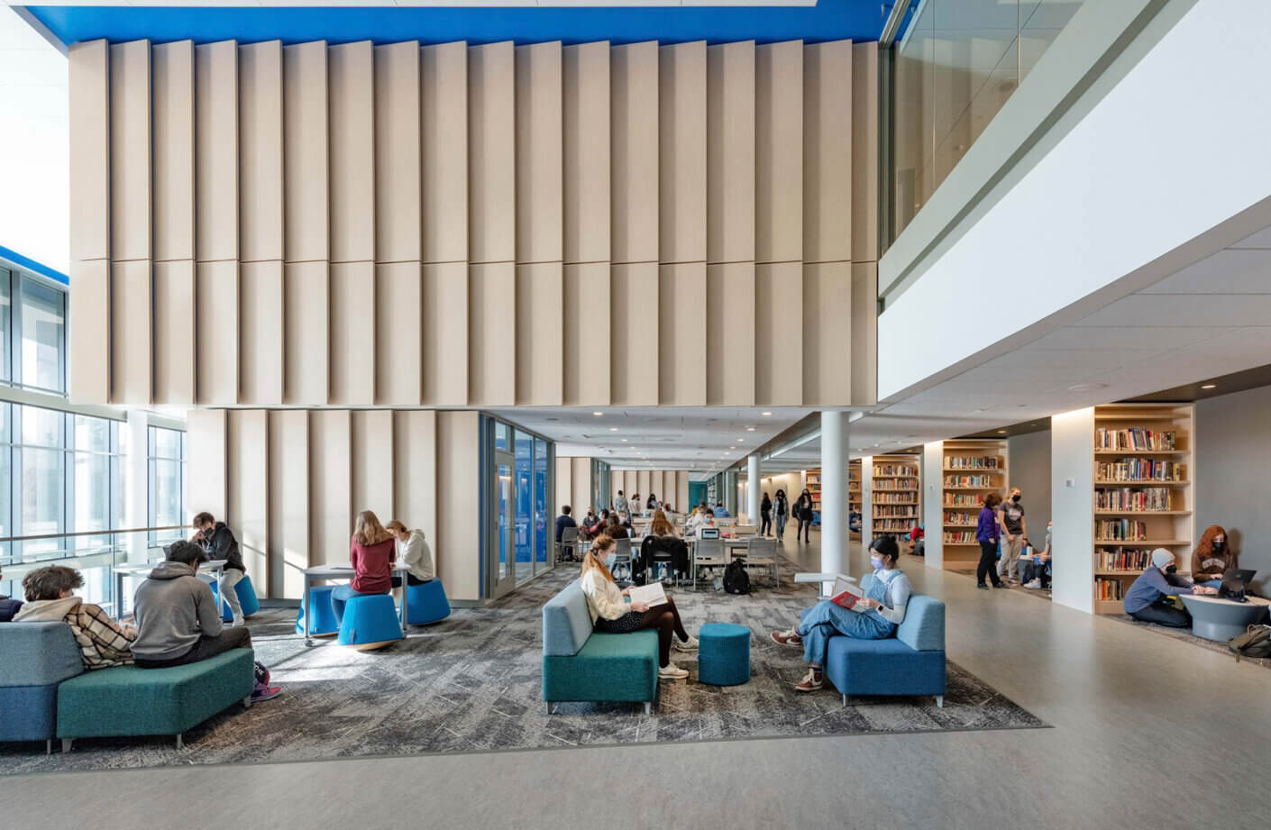 Modern library interior with students studying in a spacious, stylish environment.