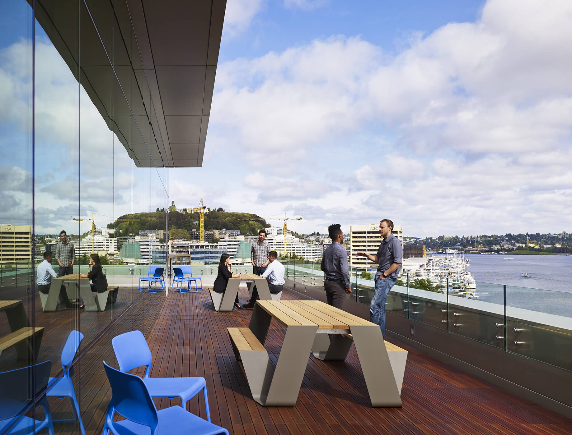 People relaxing and casually talking on deck with views to Lake Union