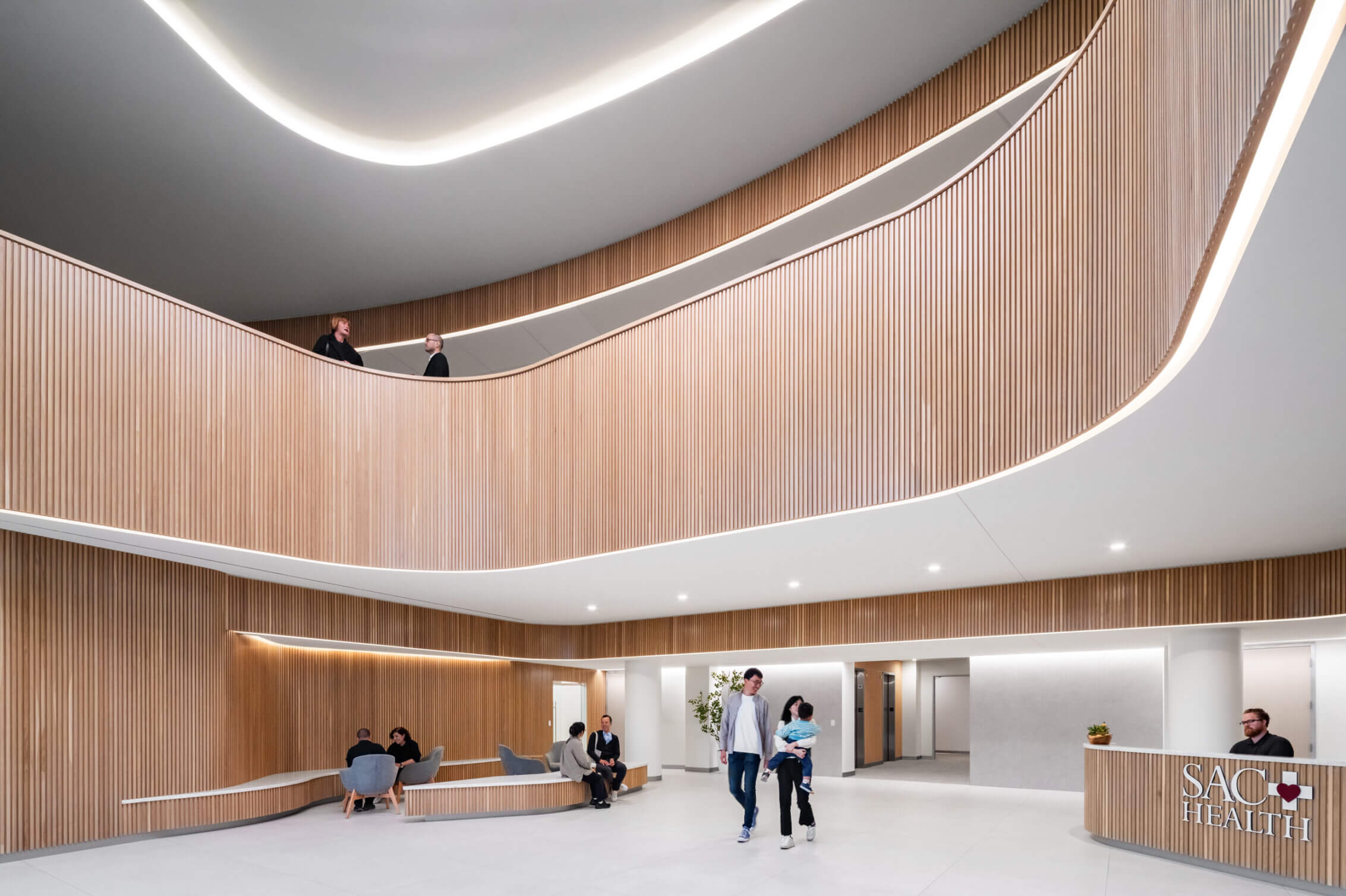 Modern healthcare lobby with wooden design and people walking.