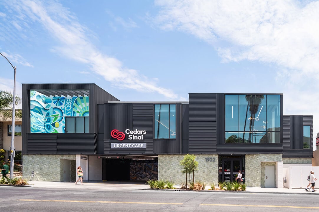 Contemporary urgent care building exterior with modern design and vibrant mural.