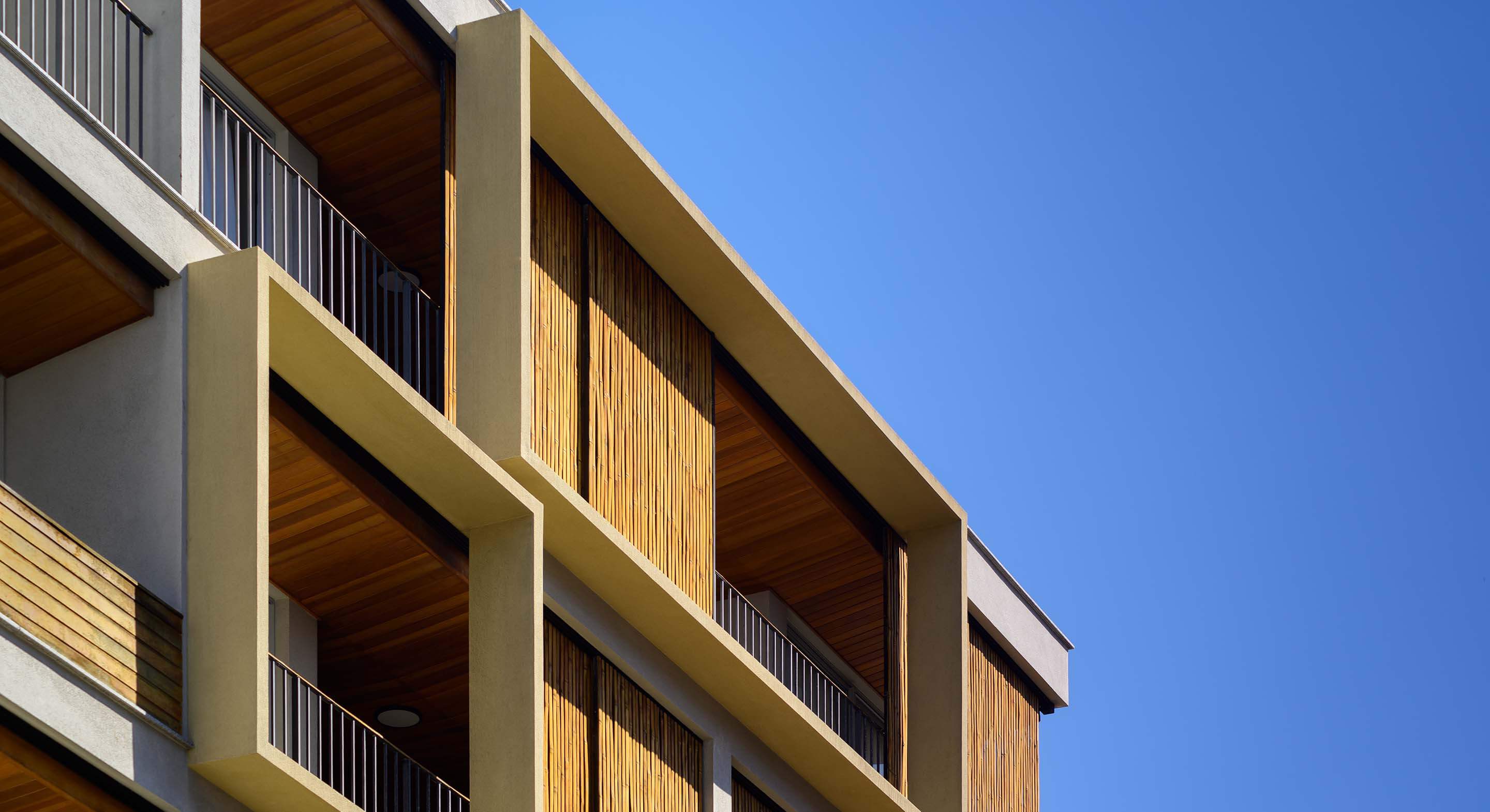 Buildin with bamboo based façade, developed by Perkins&Will São Paulo, integrated to the blue sky of Ubatuba in Brazil.