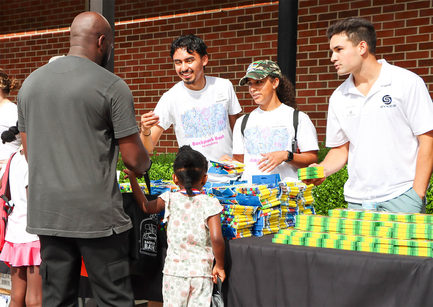 Community event with volunteers distributing school supplies to families.