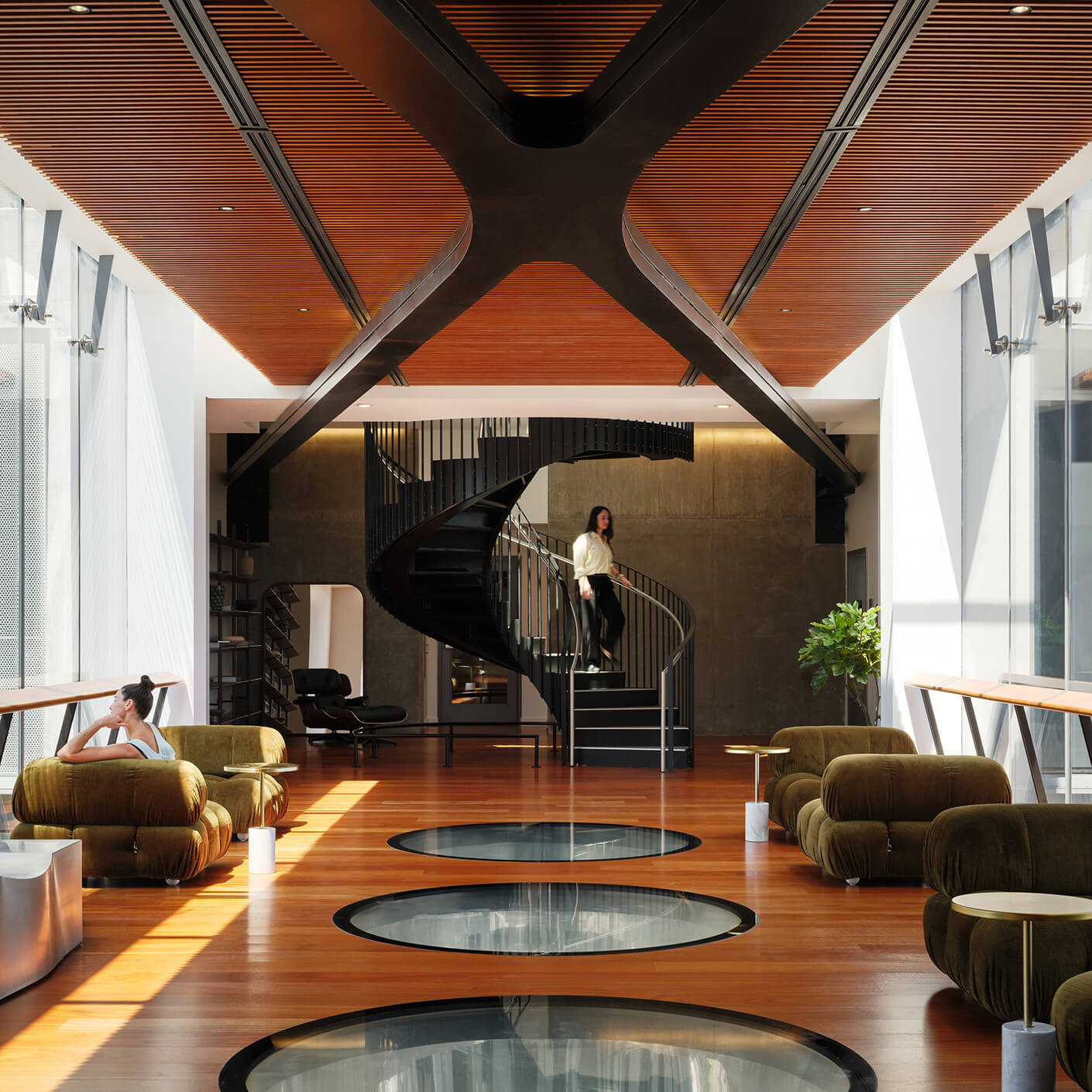 Modern interior with spiral staircase, large windows, and stylish furniture.