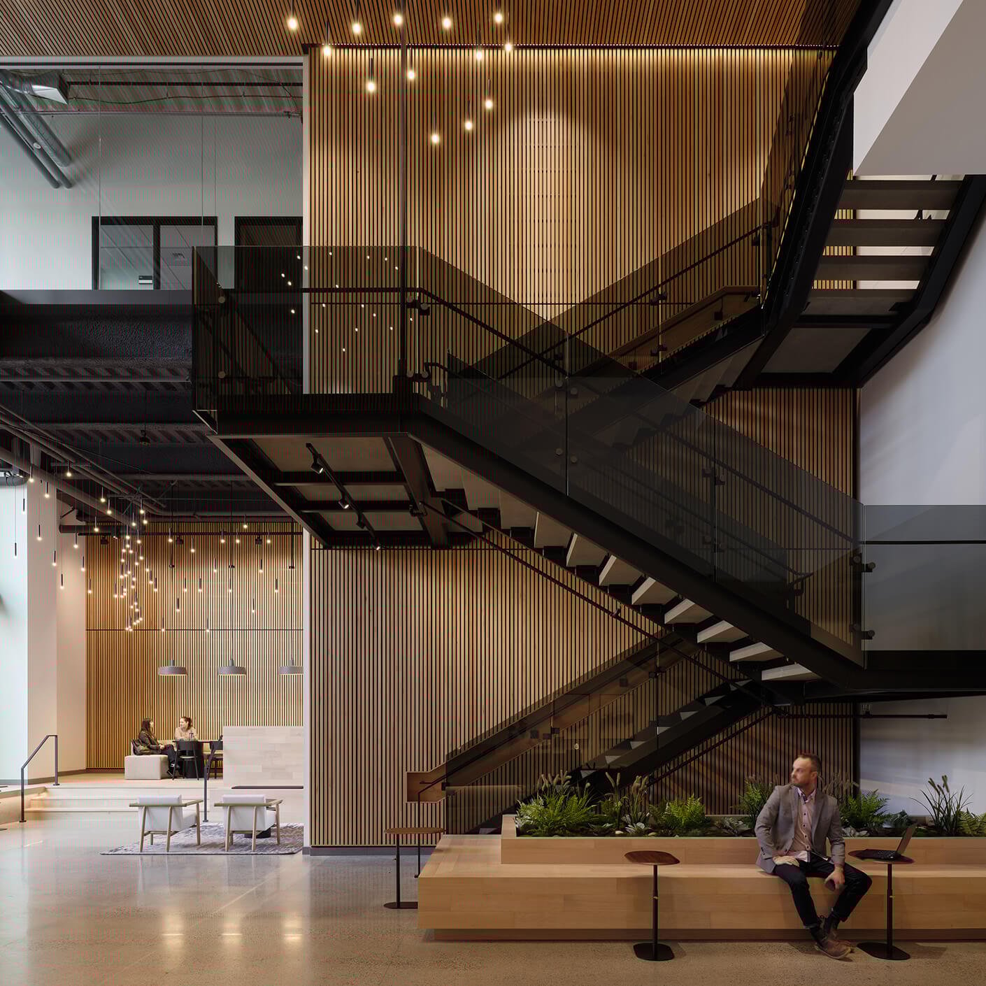 Modern office interior with wooden paneling and glass staircase.
