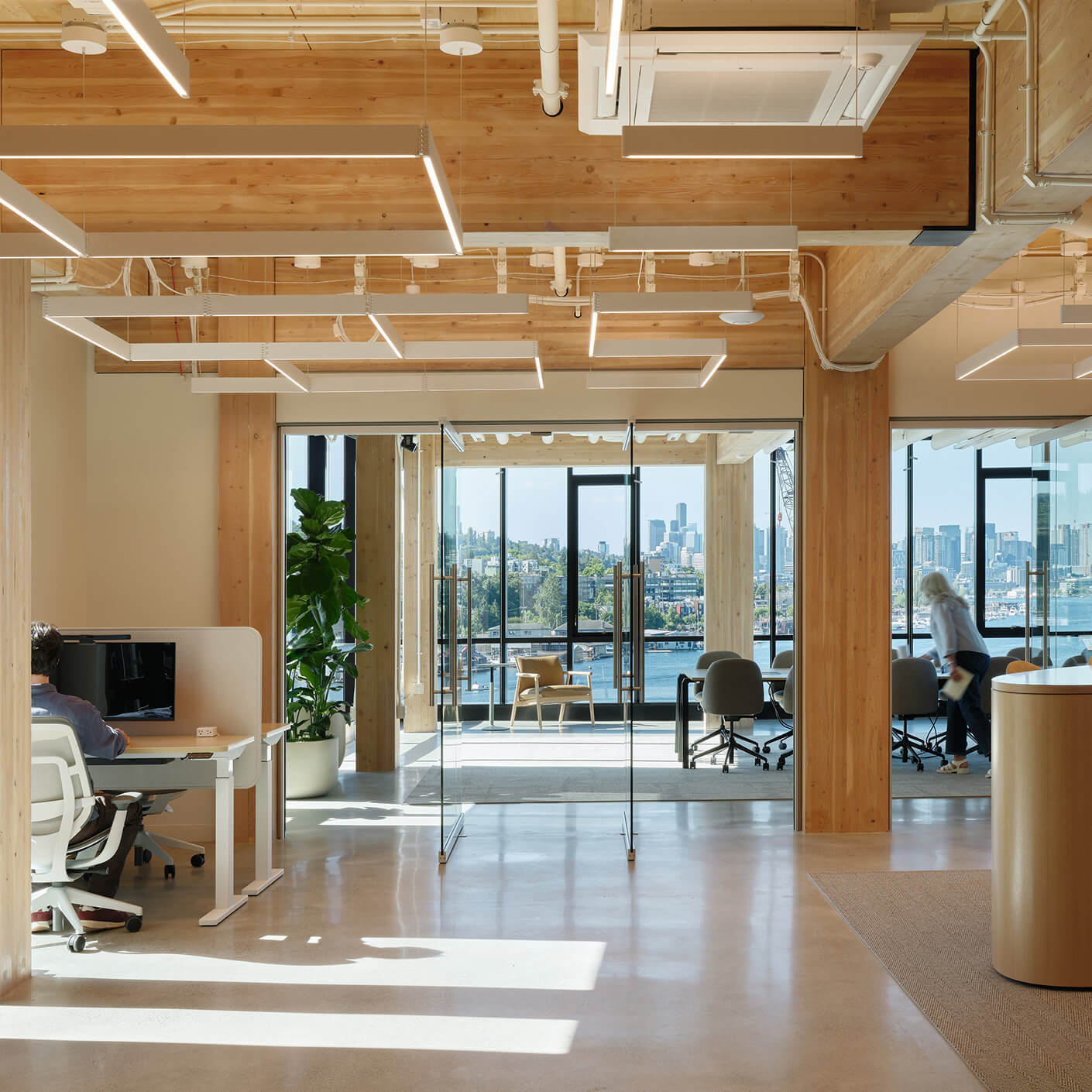 Modern open office with city view and glass walls.