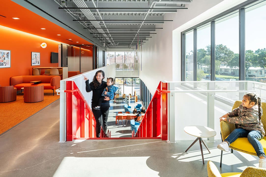Modern office interior with vibrant colors and open design, featuring a red staircase.