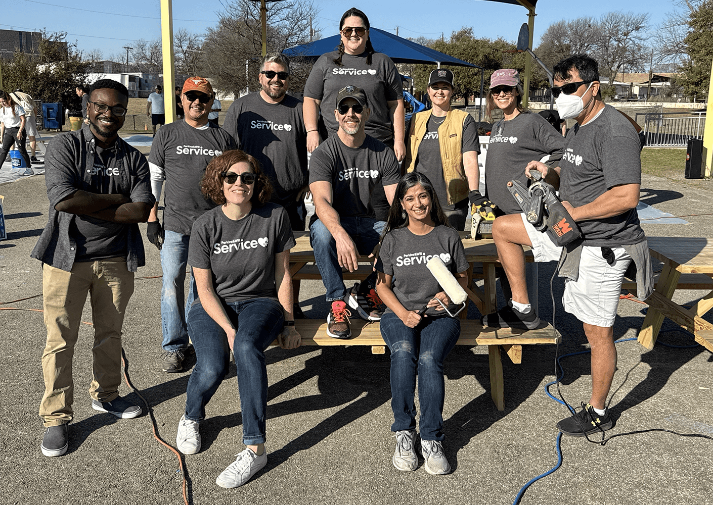 Group of volunteers in matching Service shirts participating in a community project outdoors.