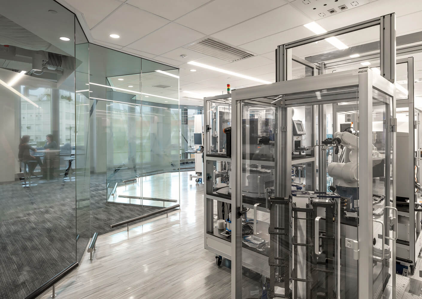 people working in an office space with windows and glass to automation labs