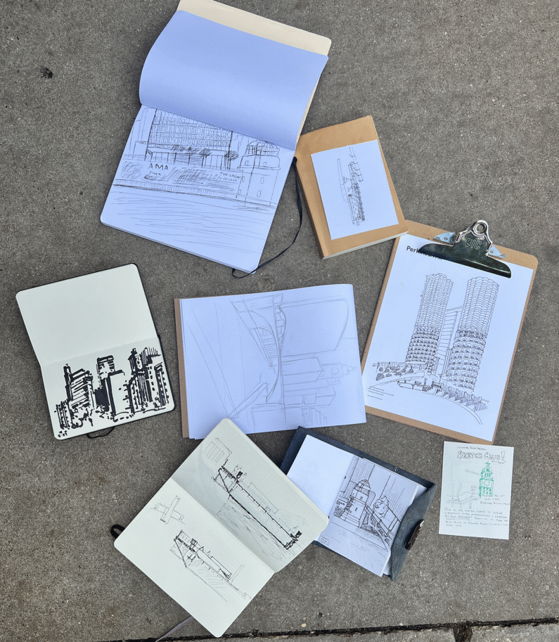 Sketchbooks with architectural drawings on a concrete surface.