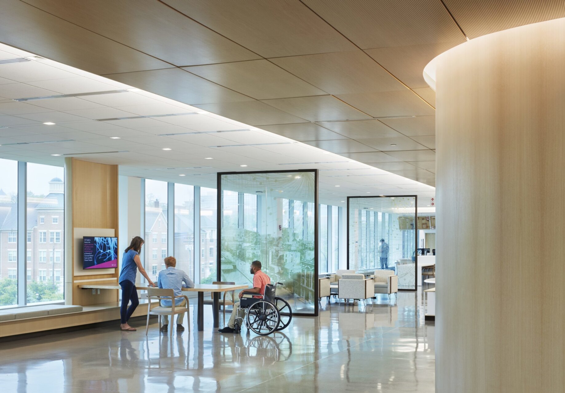 University of Cincinnati Gardner Neurological Institute. Main lobby that contains multi use areas for learning and waiting, museum, café, and classrooms. The spaces are divided by glass panels that contain artwork of the local culture of Cincinnati.