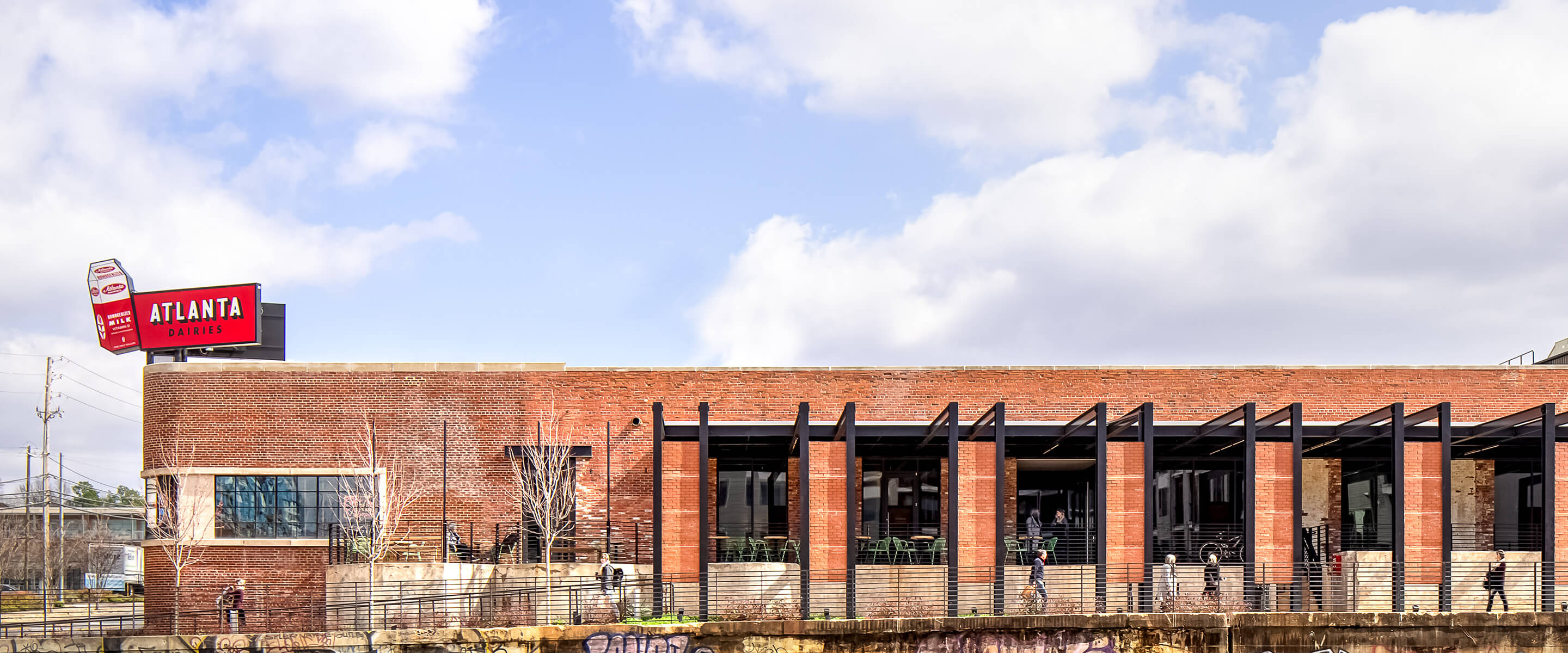 Red brick building with Atlanta Dairies sign under a cloudy sky. Features urban architecture and street view.