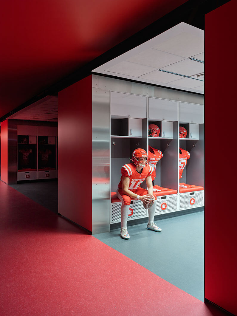 Player sitting at a locker in the football locker room.