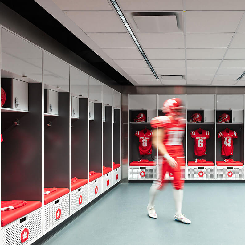 Player walking away from locker in the football locker room at SFU stadium.