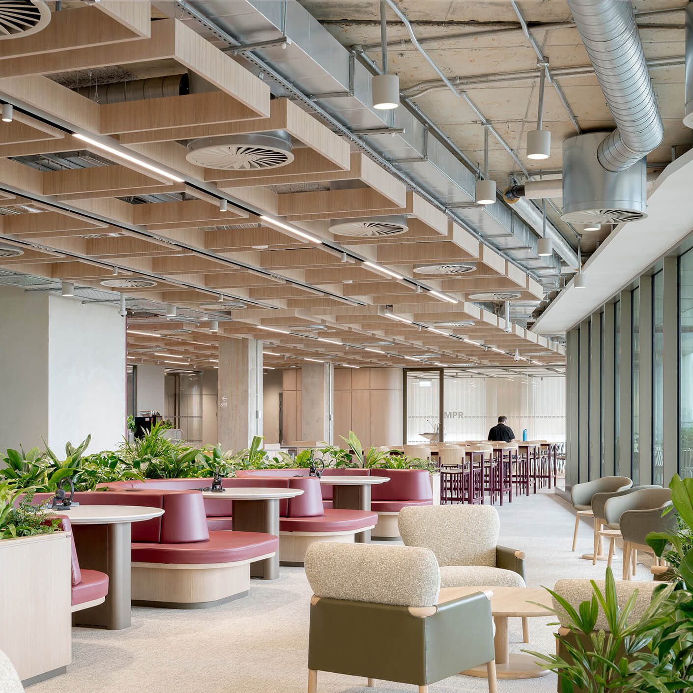 Modern, open-plan office with plants and seating.