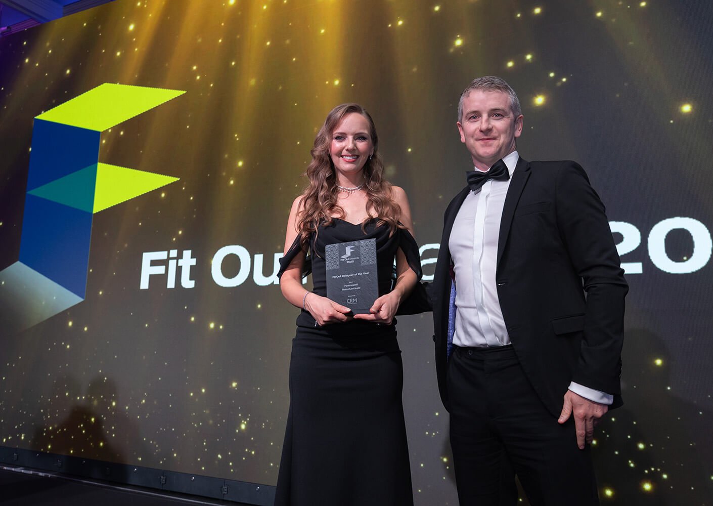 Award winners smiling on stage at the Fit Out Awards ceremony.
