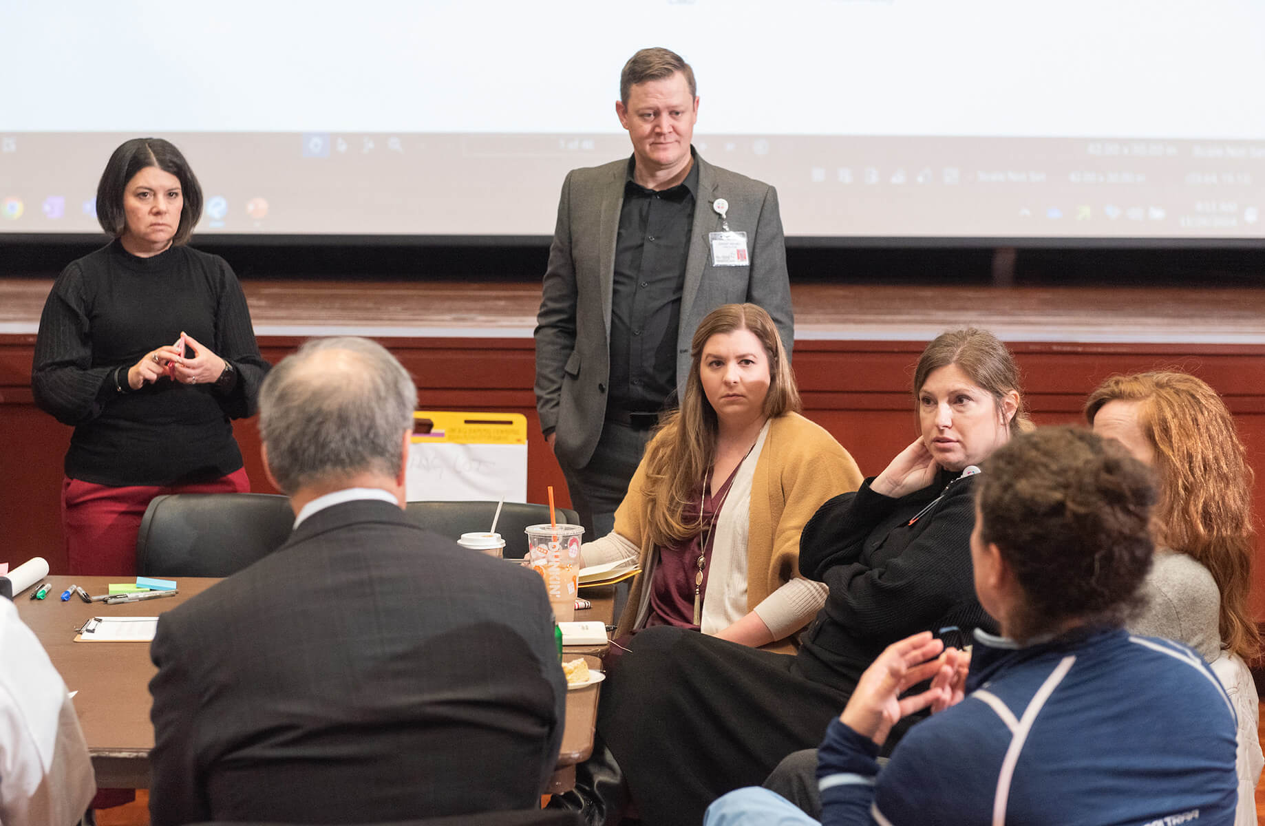Jeffrey Keilman participating in a group discussion in a conference room setup with attentive participants.