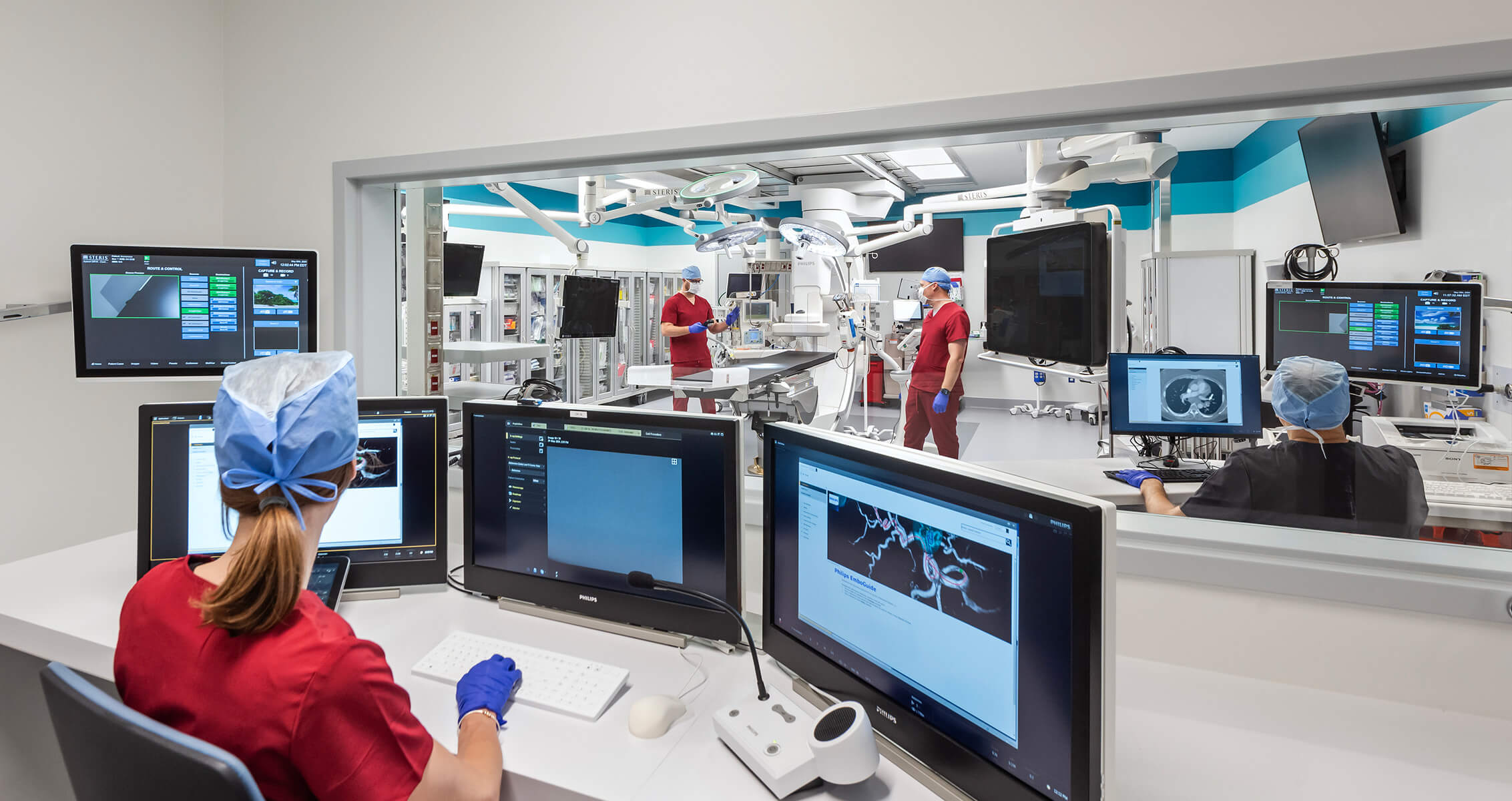 Medical team in a high-tech operating room with advanced equipment and monitors.
