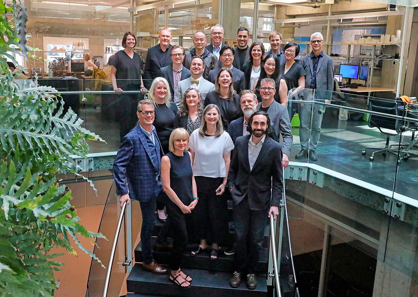 A photo of the Vancouver leadership group standing on the stair in the atrium of the Vancouver studio.
