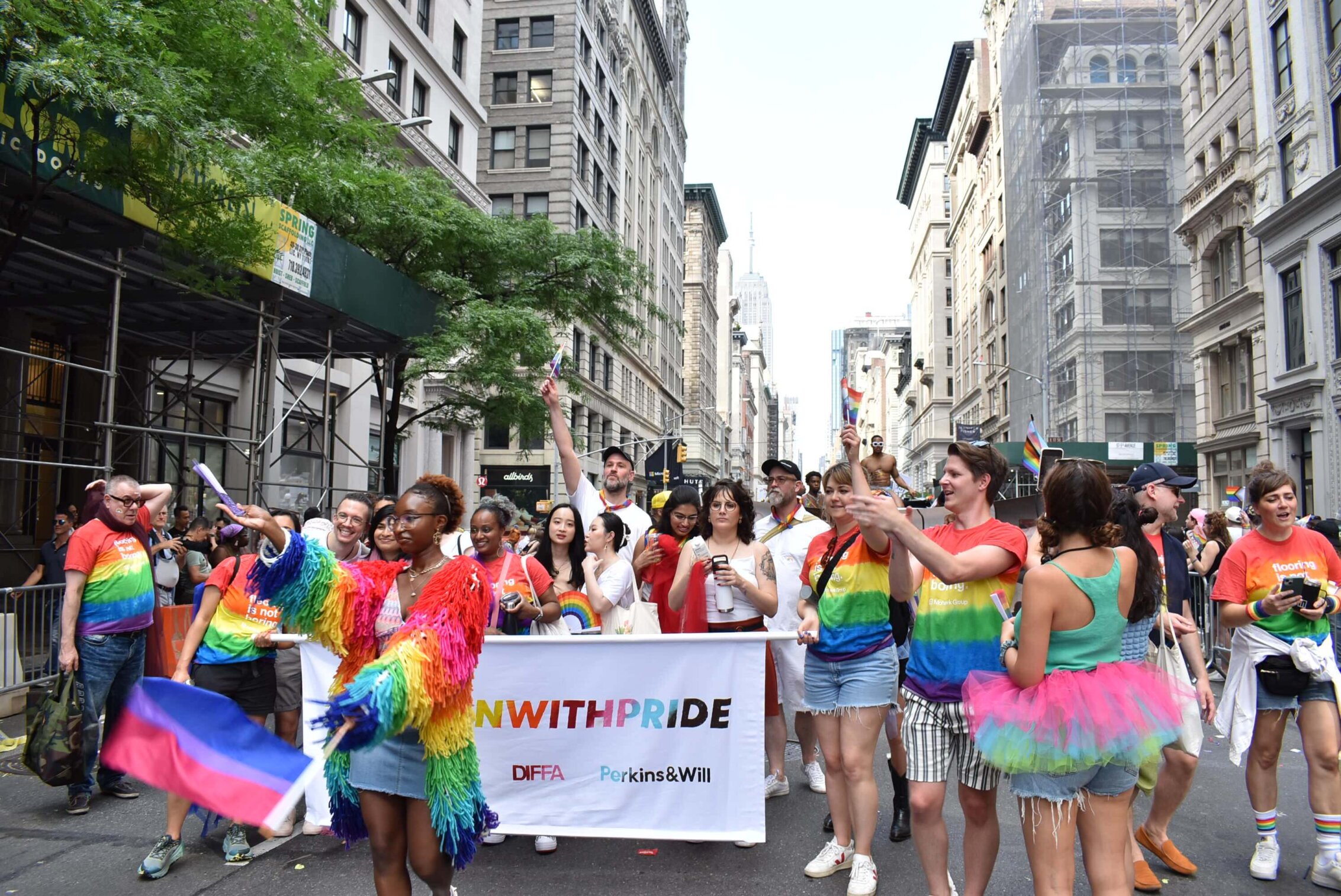 Perkins&Will's New York City studio, wearing rainbow clothing and holding flags, marches down one of the city's avenues.