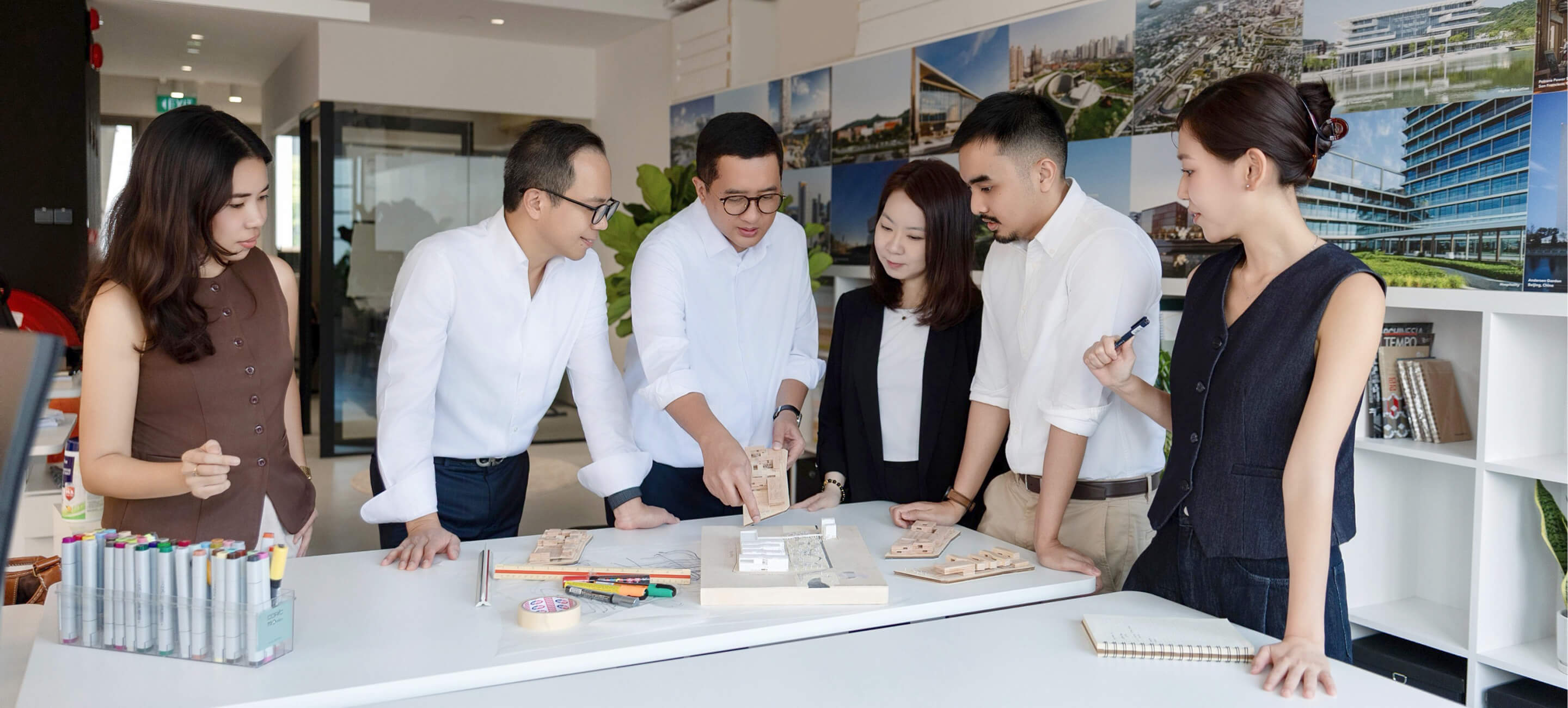 Team collaborating on architectural designs in a modern office environment.