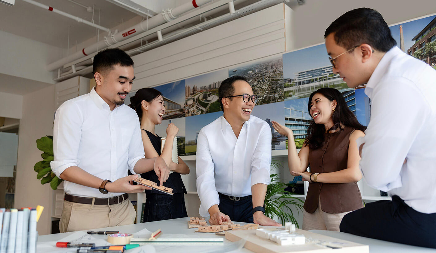 Team collaborating on architectural models in a bright, modern office space.