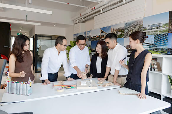 Team collaborating on a project in a modern workspace with design materials.