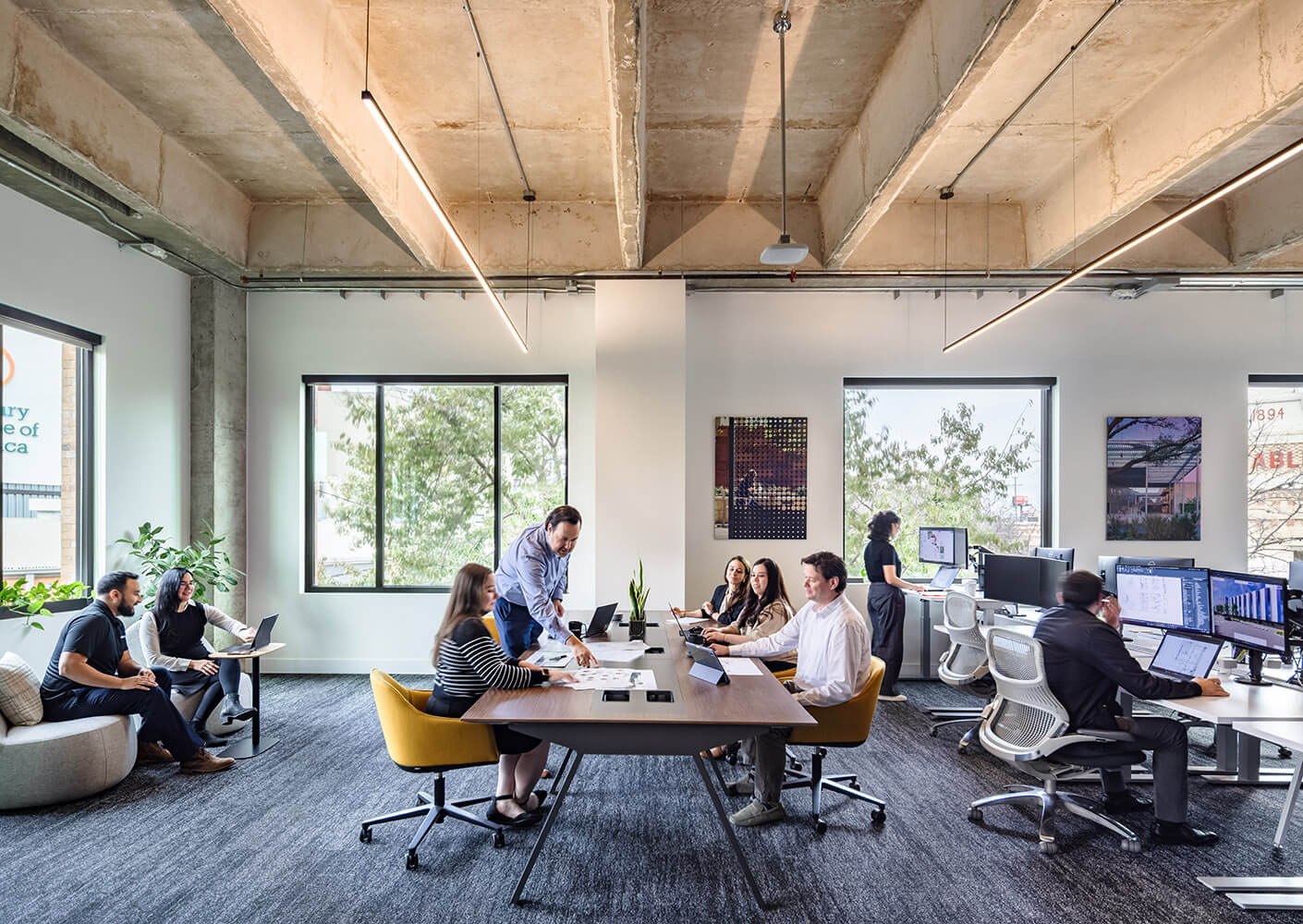 A group at work over a communal table inside the Perkins&Will San Antonio studio