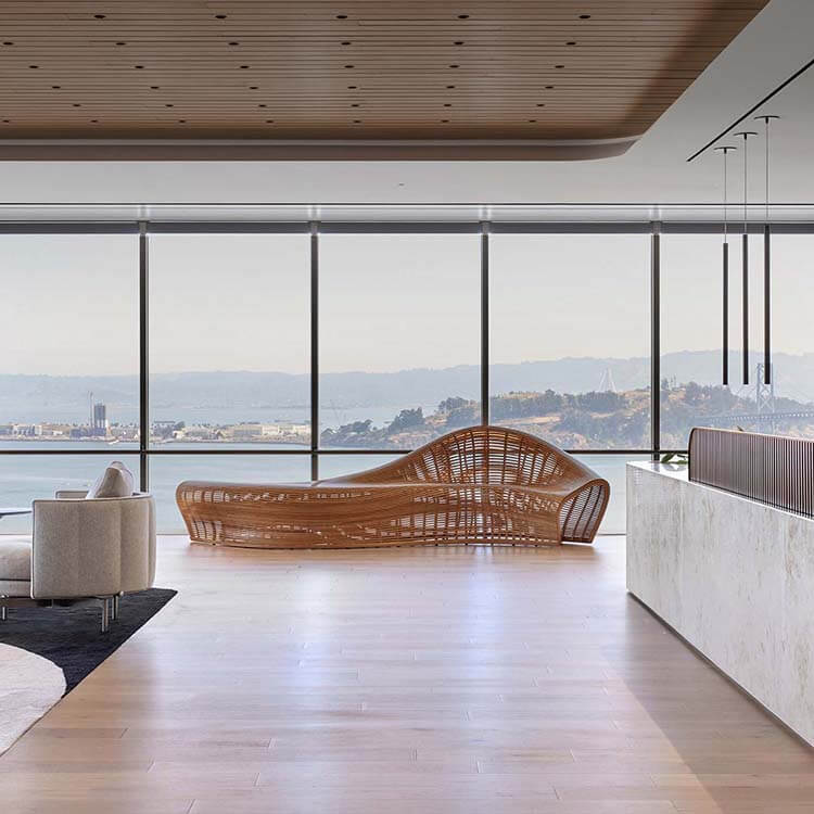 the reception area of an office, with a marble desk and woven chair overlooking the san francisco bay