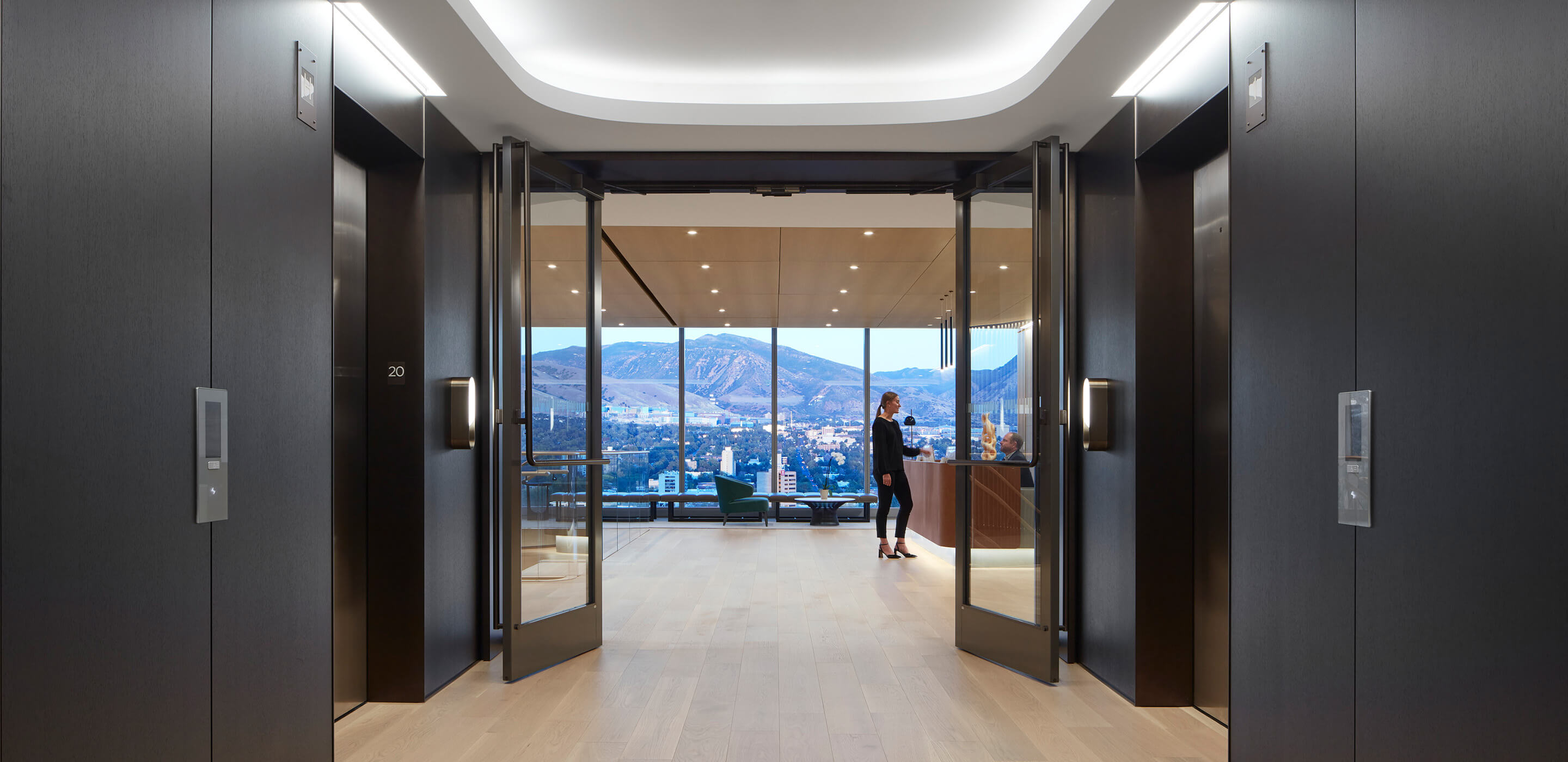 Interior of elevator lobby with reception desk and view of mountain from floor to ceiling window