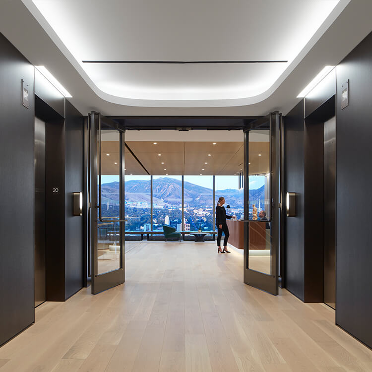 Interior of elevator lobby with reception desk and view of mountain from floor to ceiling window