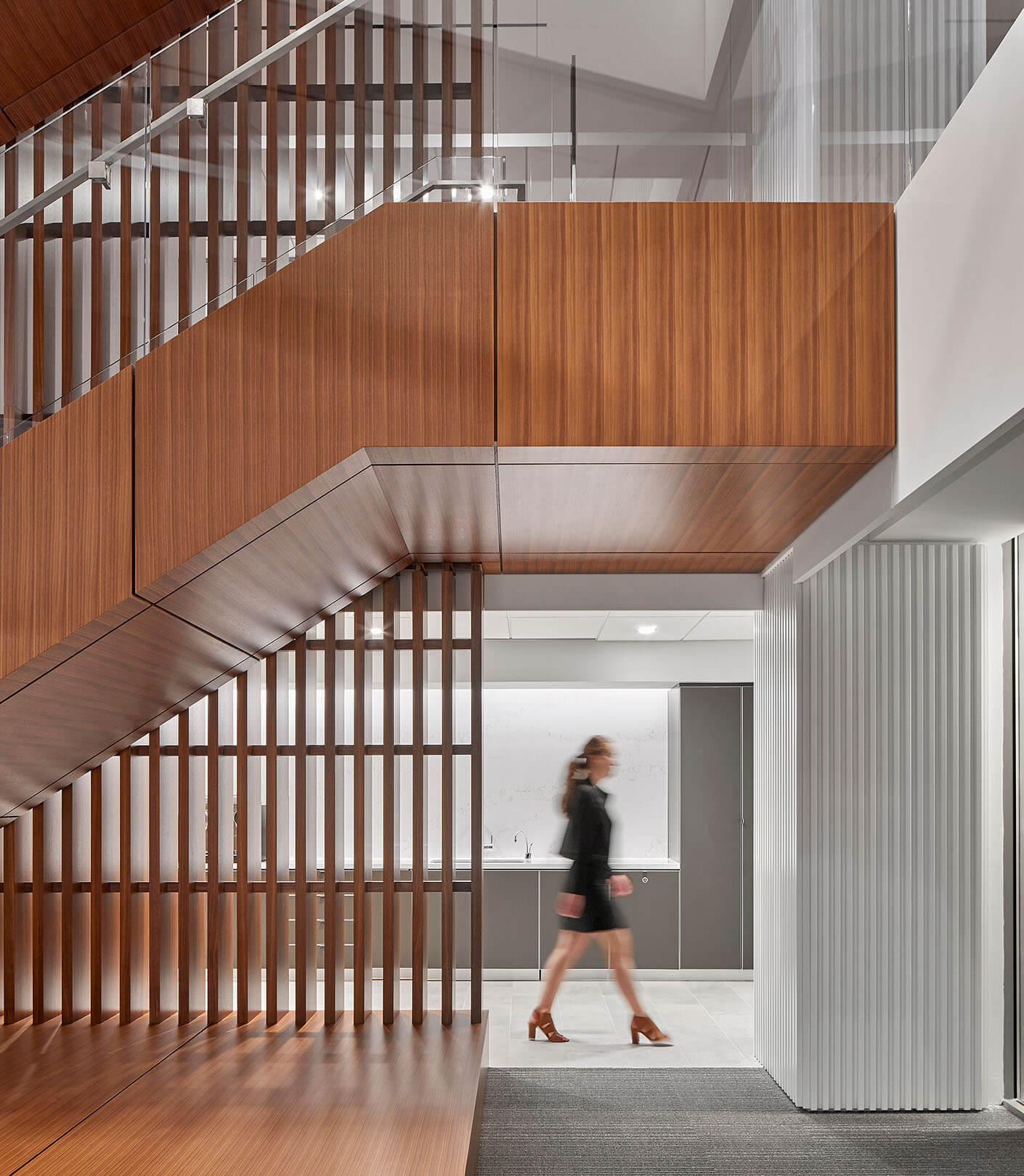 a person walks by a wood-clad stairwell