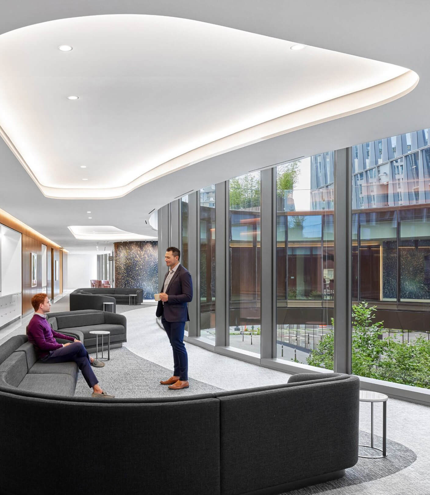 two people talk in a hallway overlooking a circular courtyard