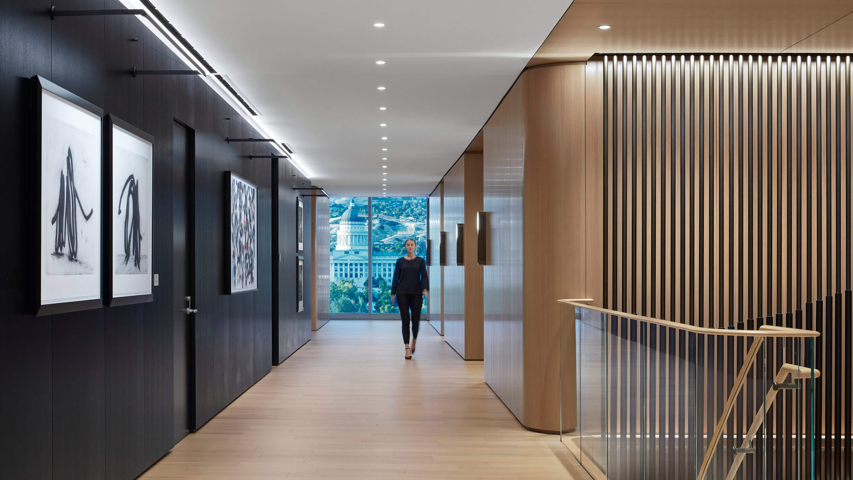 Woman walks down hallway with wood and black accent walls