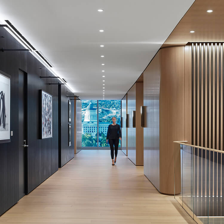 Woman walks down hallway with wood and black accent walls