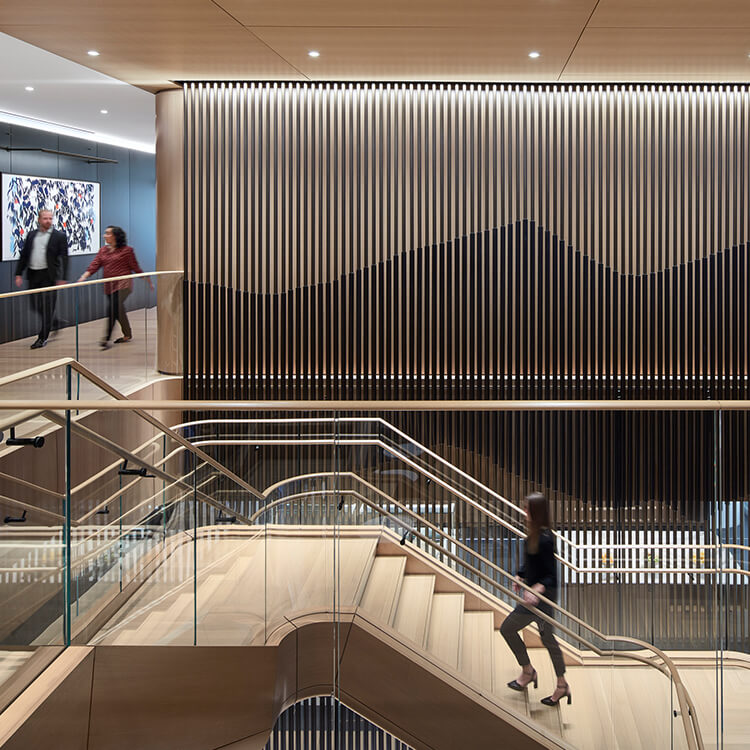 Accent wall in corporate office. People walking down hall and climbing staircase