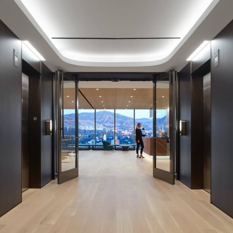 Interior of elevator lobby with reception desk and view of mountain from floor to ceiling window