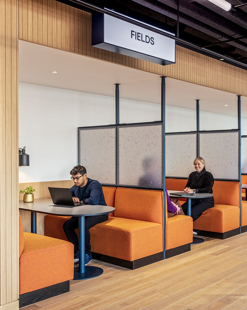 People sit individually or in small groups at enclosed booths.