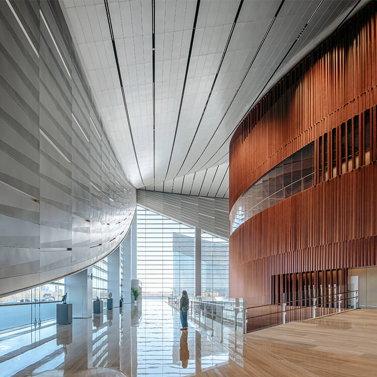 Lobby featuring pleated metal panels and large floor to ceiling windows