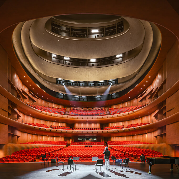 Opera house interior, person on stage looking out towards seats