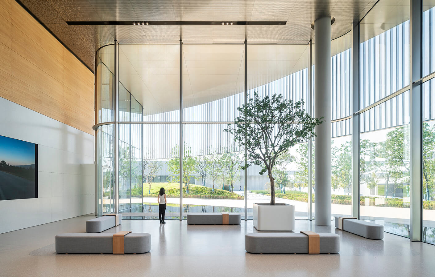 Woman stands in a lobby in front of a large window