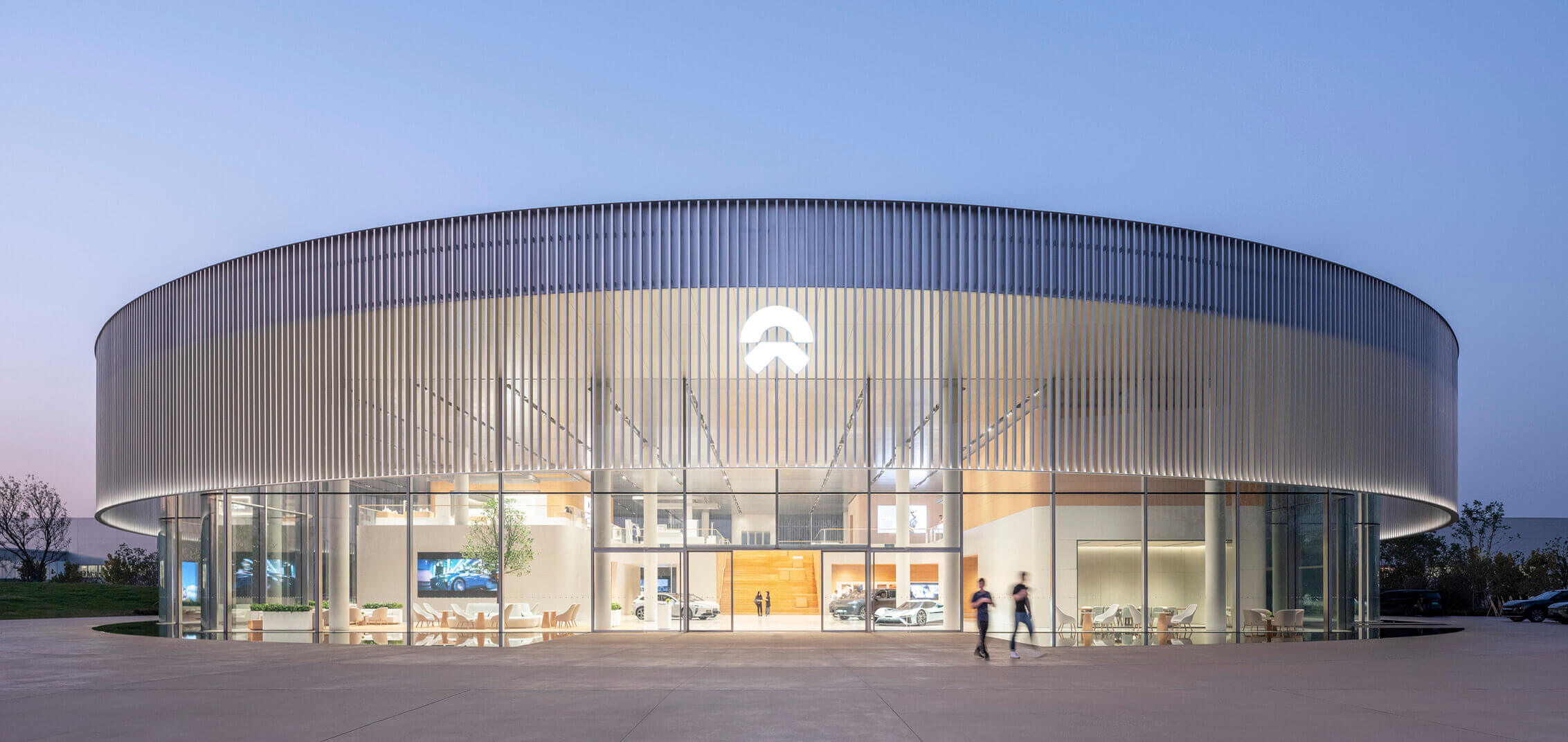 A dusk view of the entrance of an electric vehicle showroom