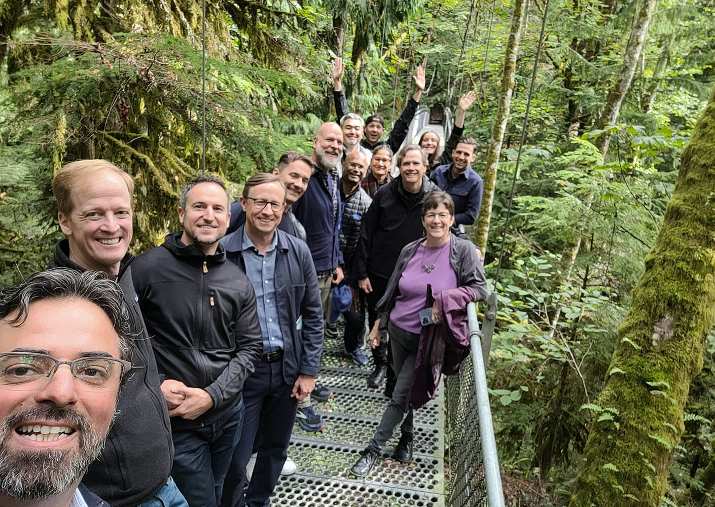 a selfie with a group of people on a suspension bridge