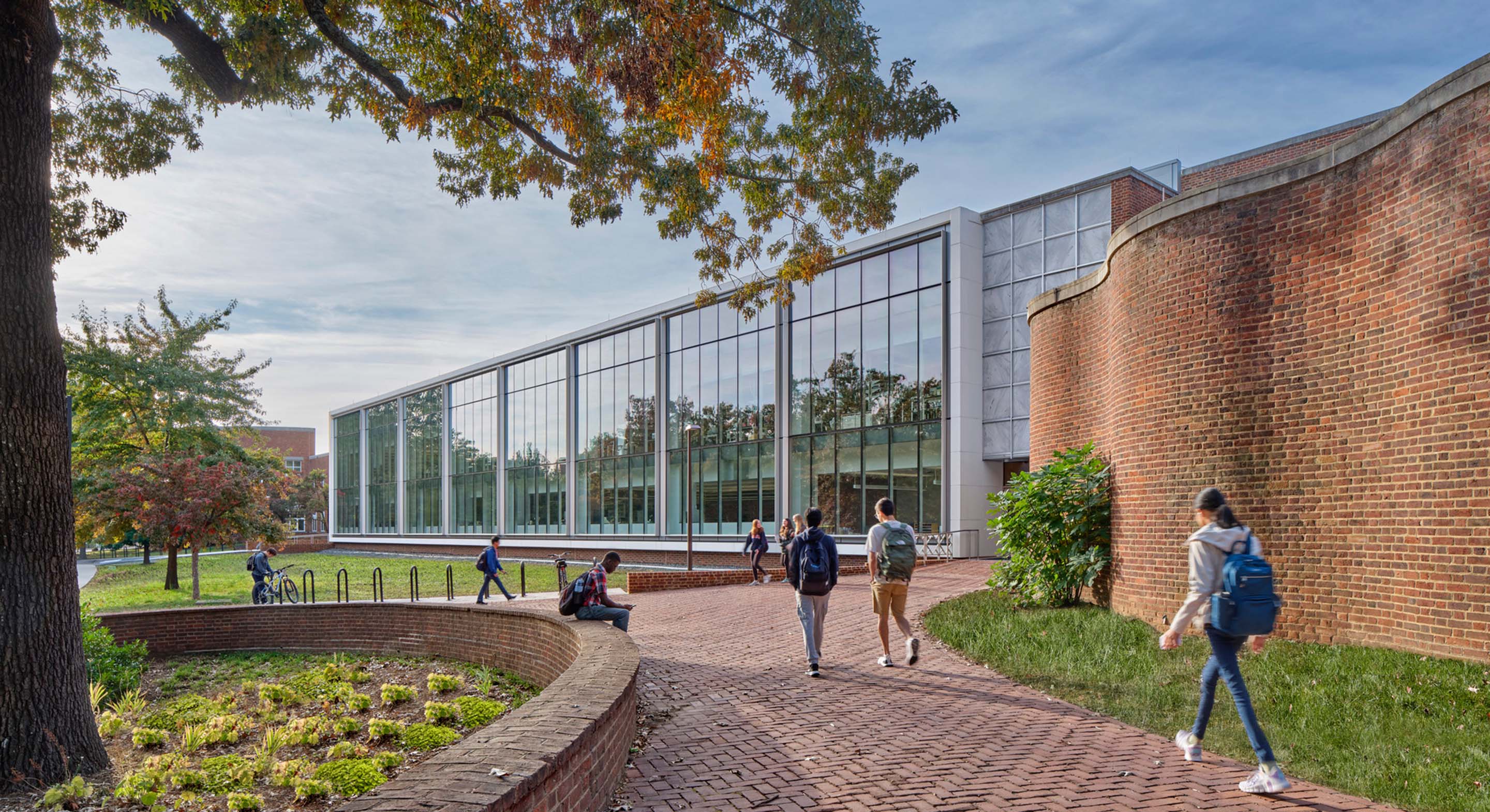 A long academic building with students in the foreground