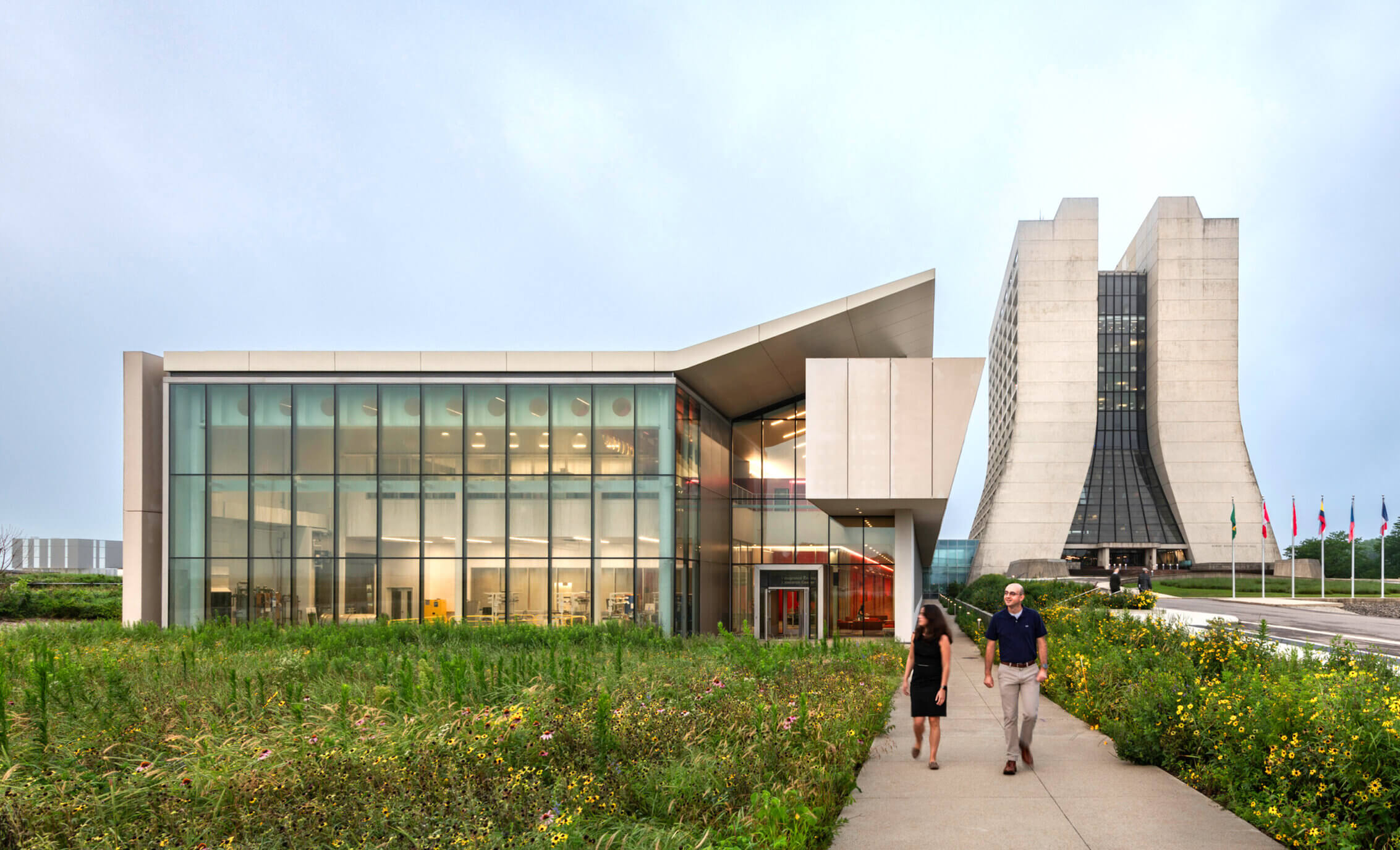 Two people walking on a sidewalk away from a lab building