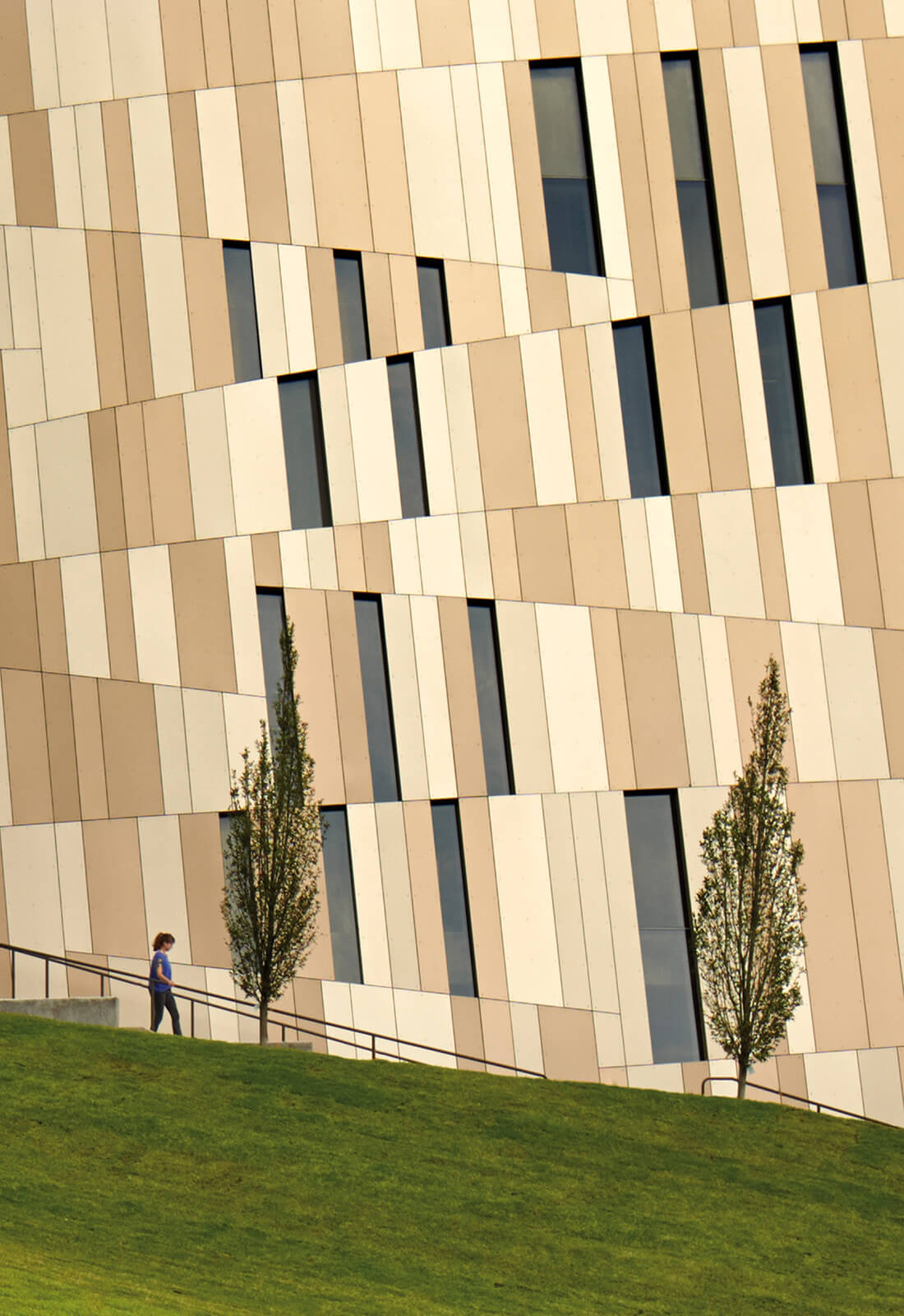 A single person walking along the exterior of the building.