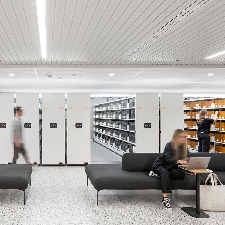 People sitting in front of white bookshelves.