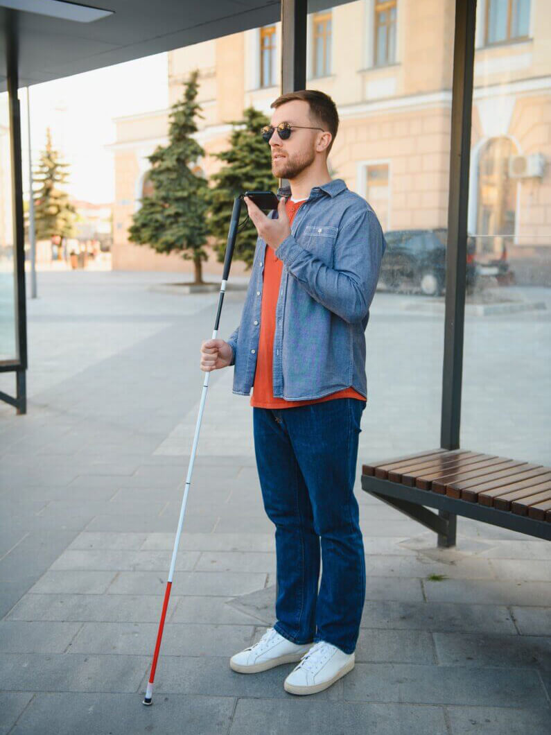 A blind man waiting for public transportation