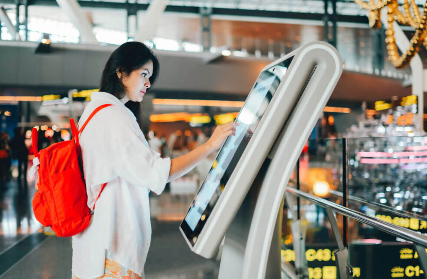 A woman using a touchscreen kiosk