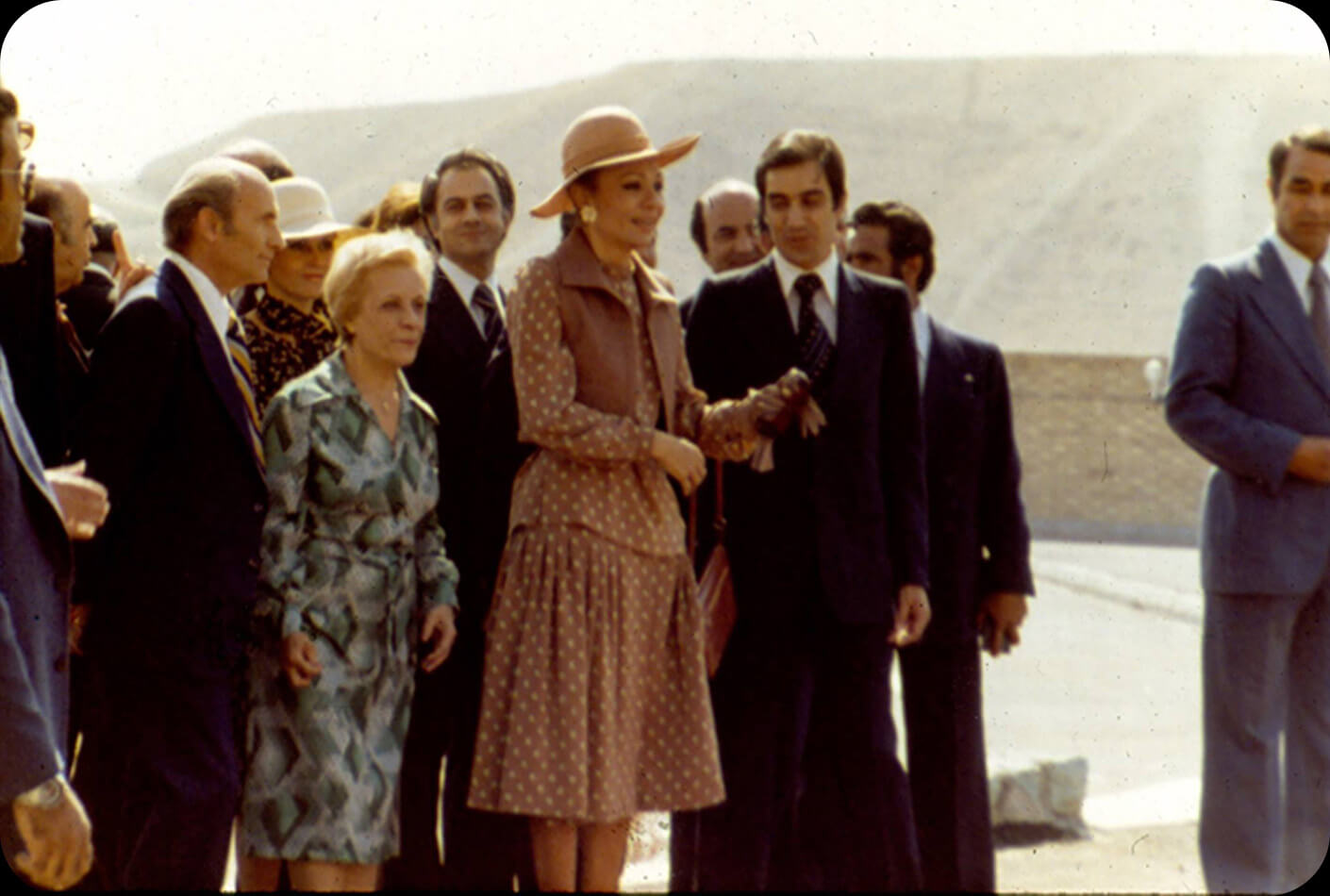 A large group of people surrounds the queen.