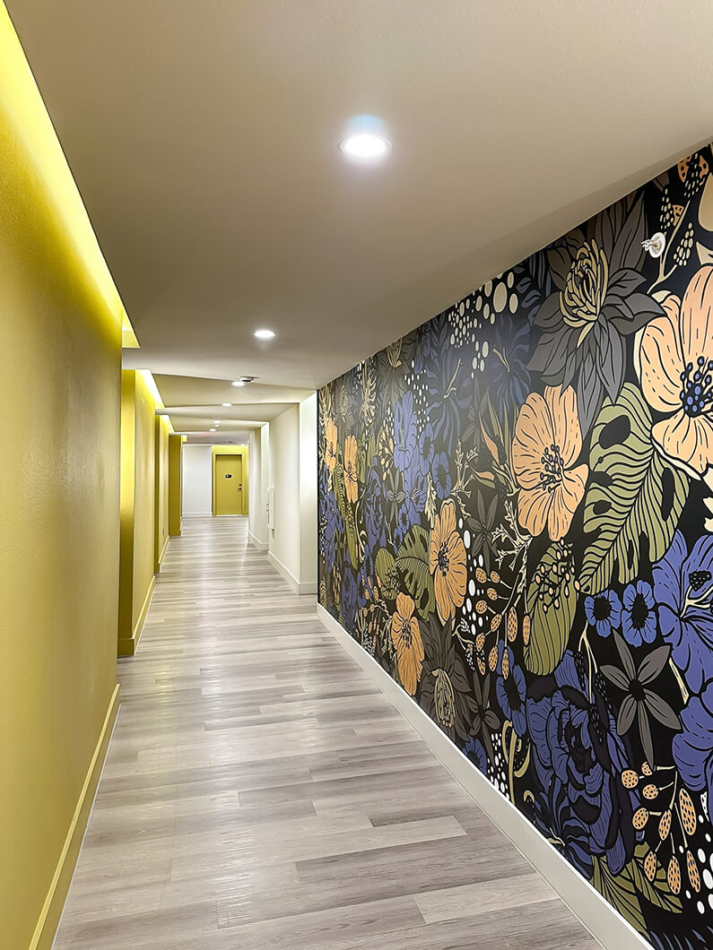 A yellow-themed residential hallway featuring a mural